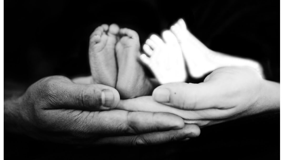 Baby feet in an adult's hands